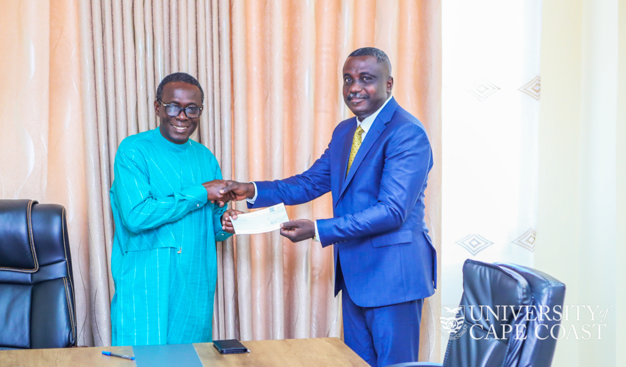 Mr. Joshua Dadzie presenting the cheque to the Vice-Chancellor, Prof. Johsson Nyarko Boampong.