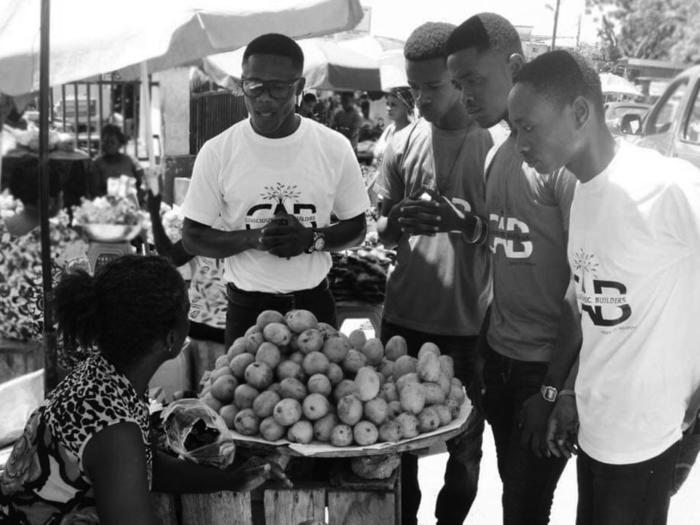 CAB Consult members interacting with a trader at the Kotokuraba Market