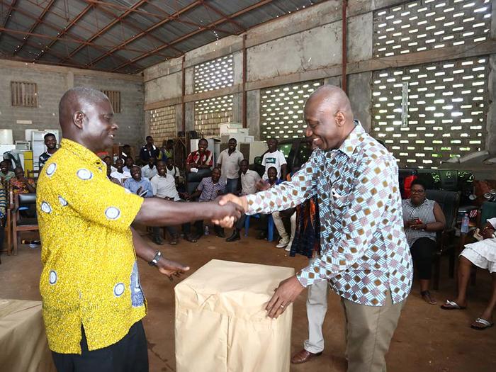 Mr. Jeff Onyame presenting a refrigerator to a retiree