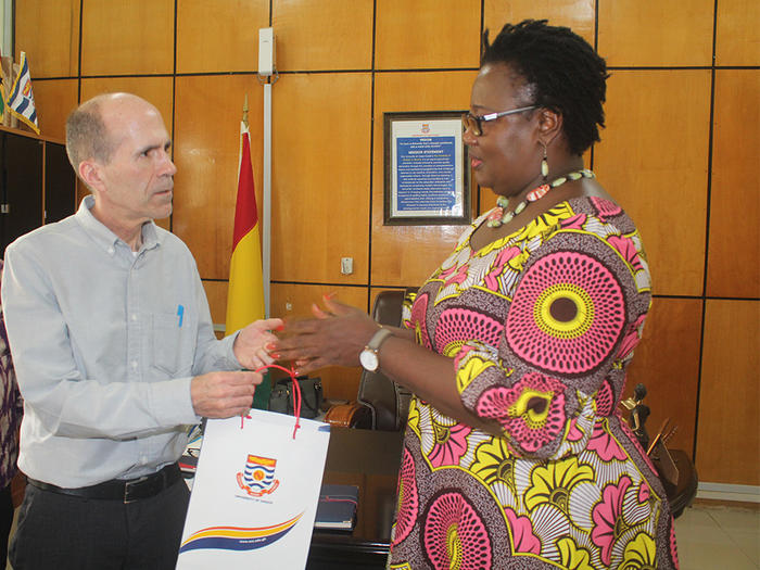 Dr. William Graves receiving UCC branded souvenir from Prof. Dora Edu-Buandoh
