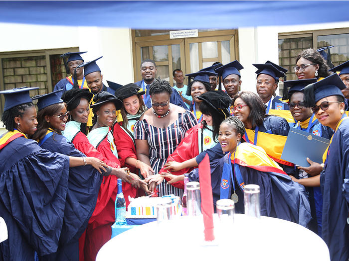 Pro Vice-Chancellor with the graduates cutting the graduation cake