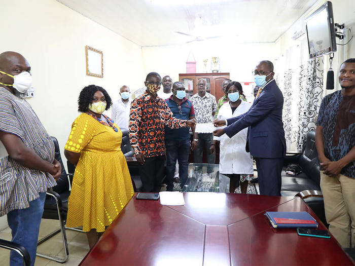 Dr. Boadi-Kusi presenting the cheque to Dr. Evans Ekanem